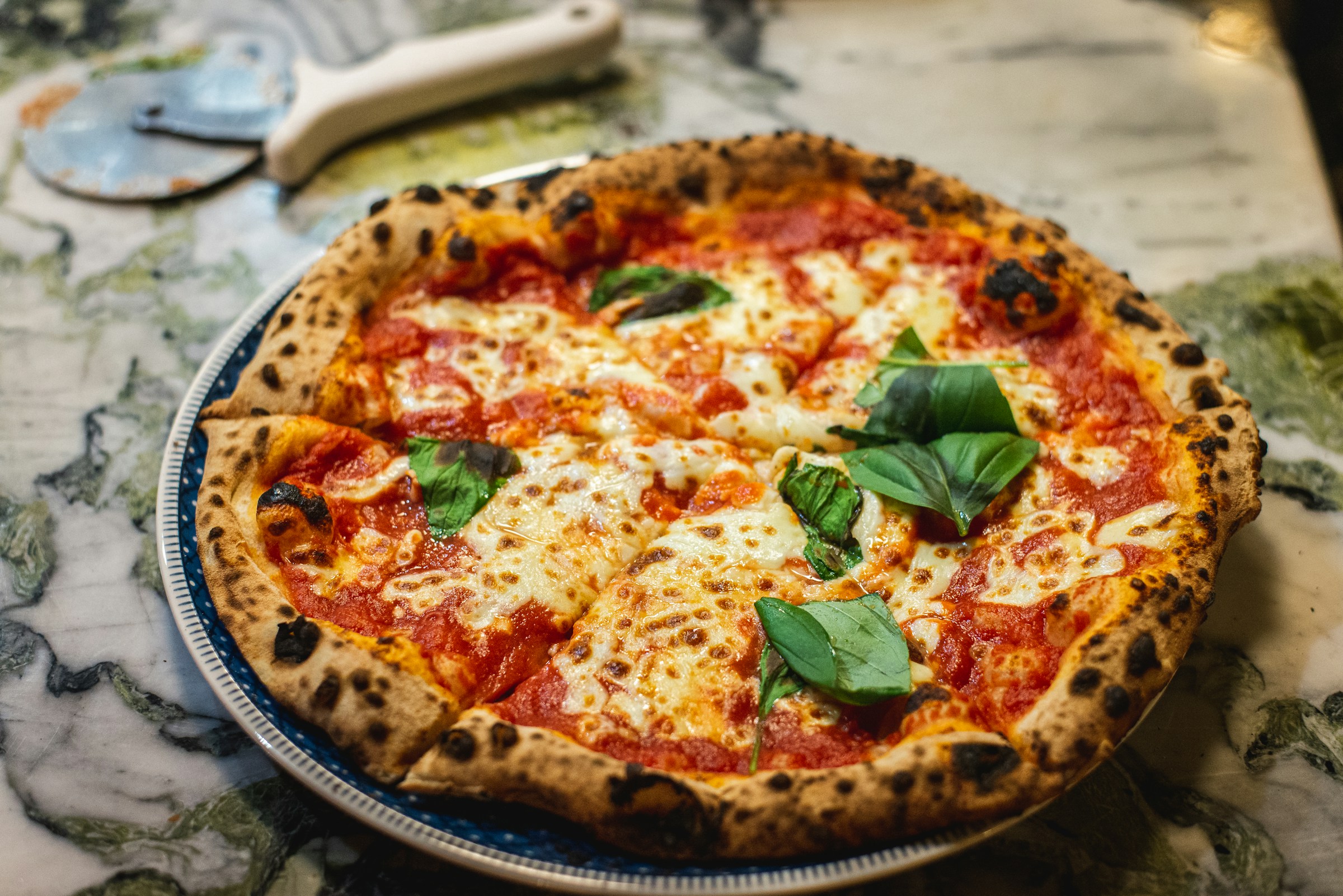 Pizzaiolo al lavoro davanti al forno a legna